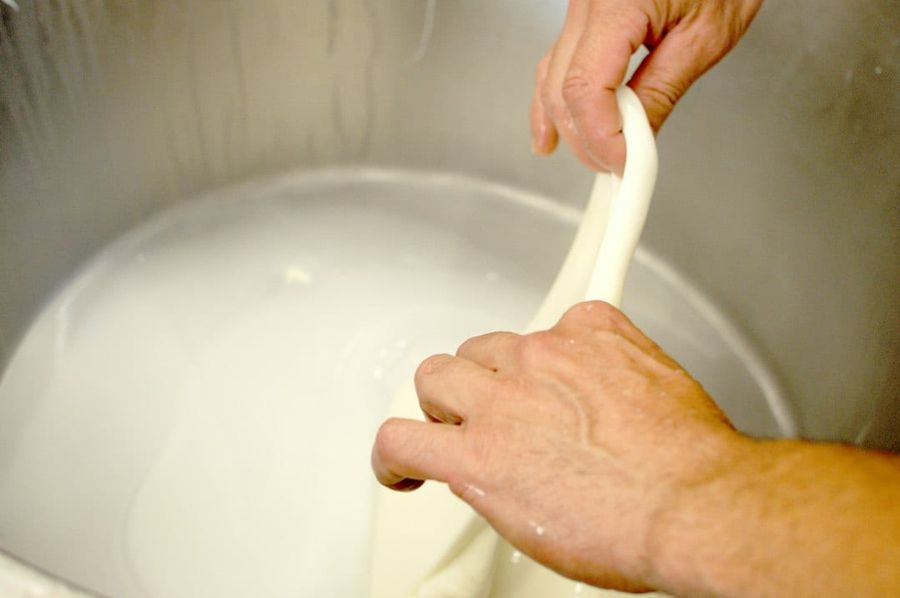 Hands gently washing silk fabric in a basin of clear water